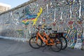 Berlin / Germany - 30 June 2018: Orange dock-less bikes for hire at East Side Gallery, a 1316ÃÂ m long remnant of theÃÂ Berlin Wall